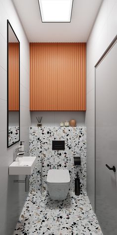 a bathroom with a toilet, sink and mirror in it's center wall that has orange slats on the walls