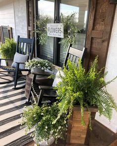 the front porch is decorated with plants and chairs
