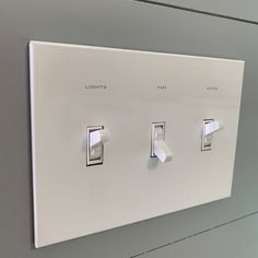 a white light switch sitting on top of a wall