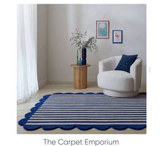 a blue and white rug with scalloped edges on the floor next to a chair