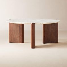 a marble top coffee table with two wooden legs on the bottom and an oval shaped base