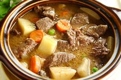 a close up of a bowl of food with broth and beef stew in it