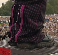 a person's boots are on top of a grill in front of a large crowd