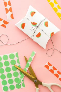 scissors, paper and other crafting supplies laid out on a pink surface with polka dots