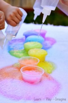 kids are painting with colored powder on the table