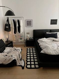 a black and white bedroom with an unmade bed