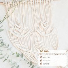 a white wall hanging with green leaves and plants