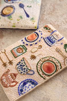 two small purses with beaded designs on them sitting on a table next to each other