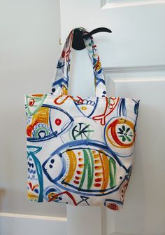 a bag hanging from the side of a door with fish painted on it's sides