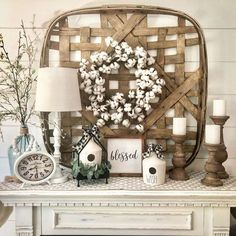 a mantle with a wreath, clock and candles on it