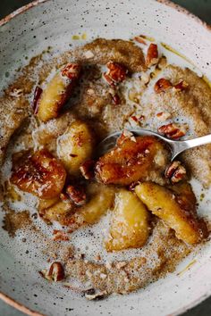 a bowl filled with bananas and nuts on top of a table