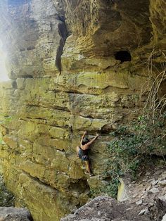 a man climbing up the side of a cliff