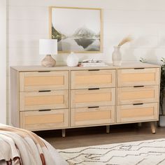 a bedroom with a bed, dresser and pictures on the wall above it that is decorated in neutral tones