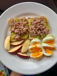 an open faced sandwich with tuna and sliced apples on a white plate, ready to be eaten