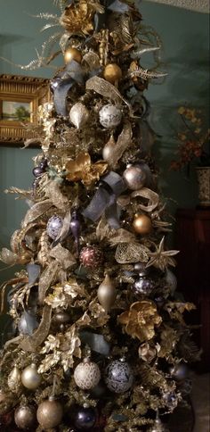 a decorated christmas tree with gold and silver ornaments