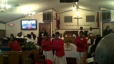 a group of people that are standing in front of a church alter with red jackets on
