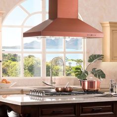 a kitchen with an oven, stove and pot on the counter in front of large windows