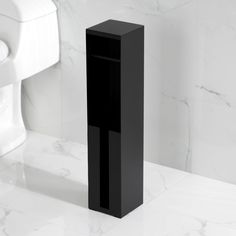 a white toilet sitting next to a black pedestal