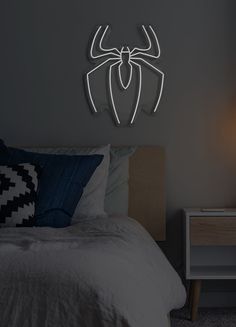 a bed with a white spider - man logo on the wall next to a night stand