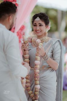 a man and woman standing next to each other in front of a wedding arch with food on it