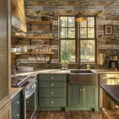 a kitchen with wooden walls and green cabinets