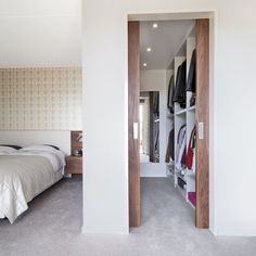 an open door leading to a bedroom with a bed and closet in the corner,