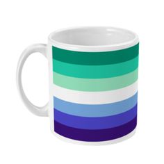 a white coffee mug with blue, green and purple stripes on the outside of it