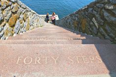 two people are walking up some steps by the water with writing on them that says forty steps