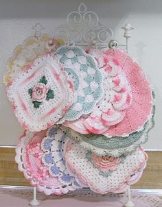 a pile of crocheted doily sitting on top of a wooden table next to a wall