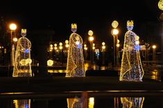 lighted statues in the middle of a park at night