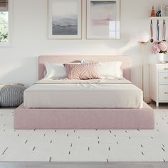 a bedroom with white walls, pink bedding and pictures on the wall above it