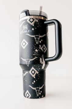 a black and white travel mug with an animal pattern on it