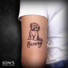 a woman with a dog tattoo on her arm that says, beny and is sitting down