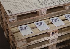 several wooden pallets stacked on top of each other with information labels attached to them