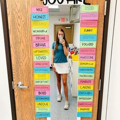 a woman standing in front of a door decorated with words