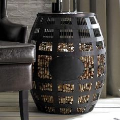 a large black basket sitting on top of a wooden floor next to a leather chair