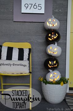 pumpkins are lit up on the side of a wall in front of a chair