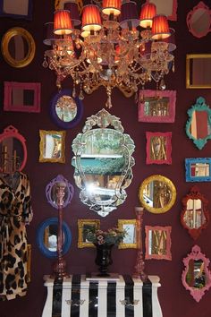 a piano is in front of a wall with many mirrors on it and a chandelier hanging from the ceiling