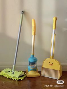 two brooms and a dust mop sitting on the floor next to each other