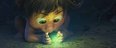 a close up of a cartoon character on the ground with a green light in his hand