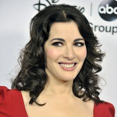 a woman in a red dress smiling at the camera