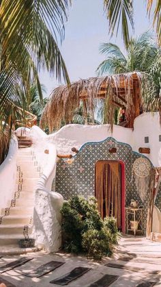 an outdoor area with palm trees and stairs leading up to the building that has been painted white