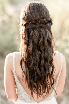 the back of a woman's head wearing a wedding dress and braided hair