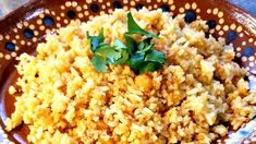 a brown bowl filled with rice and garnished with cilantro on top