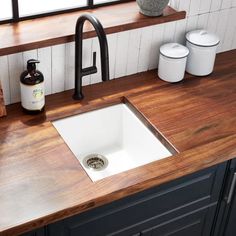 a white sink sitting on top of a wooden counter