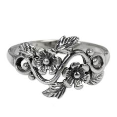 a silver ring with flowers and leaves on the front, sitting on top of a white background