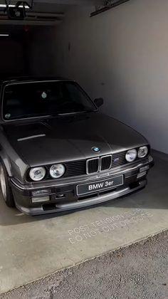 an old bmw is parked in a garage