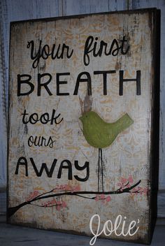 a wooden sign with a bird on it that says your first breath took ours away