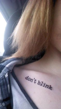 a woman with a tattoo that says don't blink on her left shoulder and chest