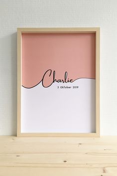 a pink and white photo frame with the word charlie on it